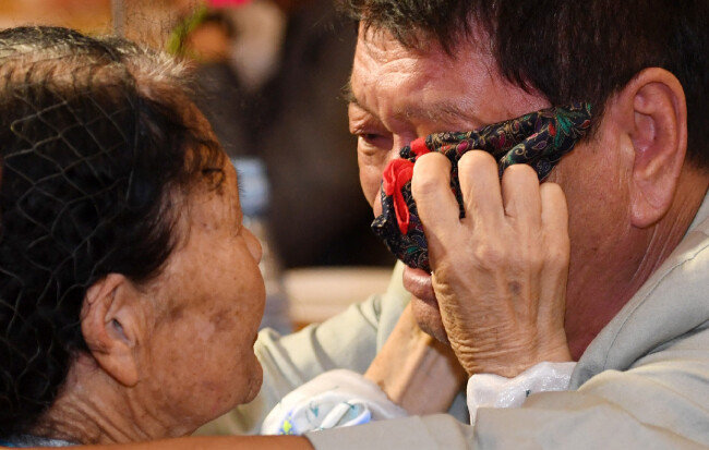 8월 26일 북한 금강산호텔에서 열린 이산가족 작별상봉에서 북측 리근숙(84·왼쪽) 씨가 남측 동생 황보우영(69) 씨의 눈물을 닦아주고 있다. [동아DB]