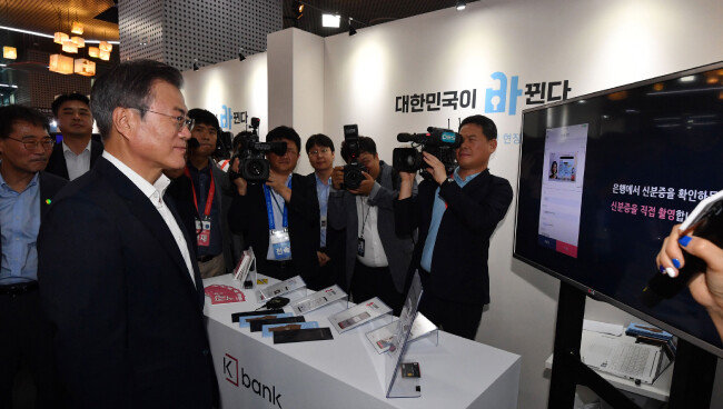 문재인 대통령이 8월 7일 서울 중구 서울시 시민청 활짝라운지에서 열린 인터넷전문은행 규제혁신 현장 간담회에서 설명을 듣고 있다. [동아DB]