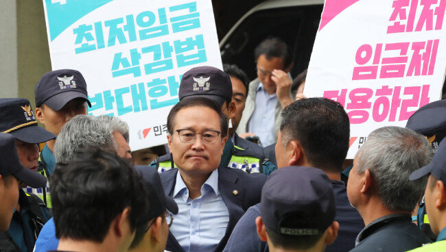 홍영표 더불어민주당 원내대표가 2018년 6월 10일 제주시 문대림 당시 제주지사 후보 선거사무소 앞에서 민주노총 제주본부 관계자들과 대화하고 있다. 이날 문 후보 선거사무소 앞에서는 최저임금 산입범위 확대법 폐기를 요구하는 민주노총의 항의 시위가 벌어졌다. [뉴스1]