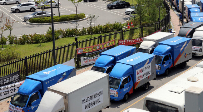 CJ대한통운 (협)전국택배대리점연합 소속 택배 기사들이 2018년 7월 16일 정부세종청사 고용노동부 앞에서 집회를 열고 고용부에 택배연대노조의 배송 방해 행위를 중단시킬 것을 촉구하며 청사 주변에 택배 화물차를 세워놓고 있다. [뉴스1]