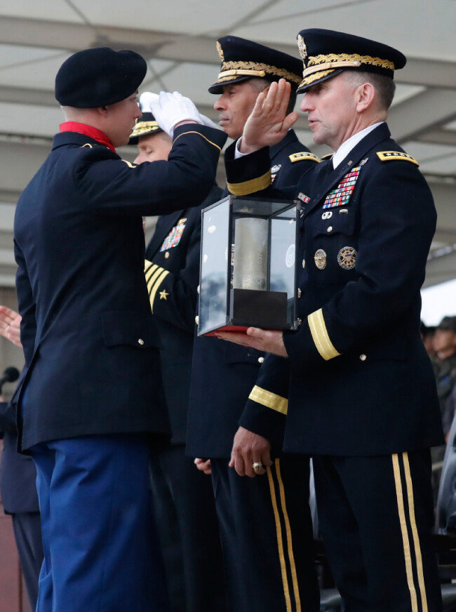 2018년 11월 8일 경기 평택 미군기지에서 로버트 에이브럼스 신임 한미연합사령관(오른쪽)이 주한미군의 전통에 따라 장병으로부터 이·취임식 예포의 첫 탄피를 전달받은 후 경례하고 있다. [뉴시스]