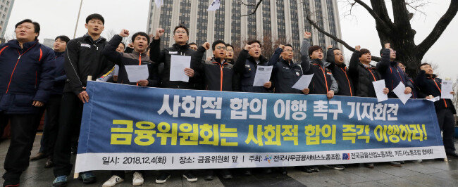 전국사무금융서비스노조, 전국금융산업노조, 카드사노조협의회 조합원들이 2018년 12월 4일 서울 종로구 정부서울 청사 앞에서 금융위원회를 향해 카드사 구조조정 방지 방안 마련 수립을 촉구하고 있다. [뉴스1]