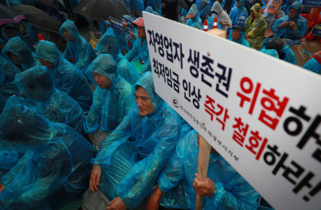 2018년 8월 29일 오후 서울 종로구 광화문광장에서 열린 ‘전국 소상공인 총궐기’ 집회에 참가한 참가자들이 우의를 입은 채 구호를 외치고 있다. [동아DB]