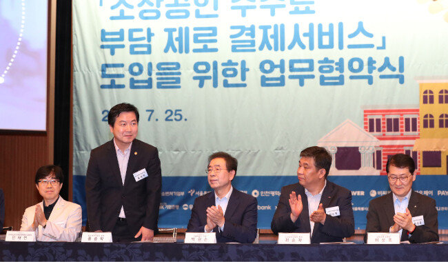2018년 7월 25일 서울 중구 대한상공회의소에서 소상공인 수수료 부담 제로 결제서비스 도입을 위한 업무협약식이 열렸다. 왼쪽 두 번째부터 홍종학 중소벤처기업부 장관, 박원순 서울시장, 최승재 소상공인협회장, 위성호 신한은행장. [동아DB]