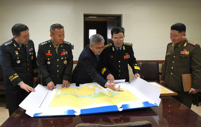 1월 30일 판문점 공동경비구역 군정위회의실에서 황준 해양수산부 수로조사과장(가운데)이 북측에 한강하구 해도 내용을 설명하고 있다. [국방부 제공]