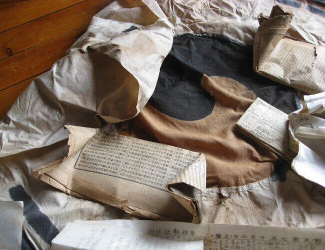 태극기 안에 싸여 있던 일제강점기 신문 자료 발굴 모습. [진관사 제공]