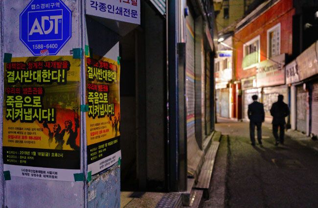 어둠이 내려앉은 을지로 골목에 청계천 재개발을 반대하는 벽보가 붙어 있다.