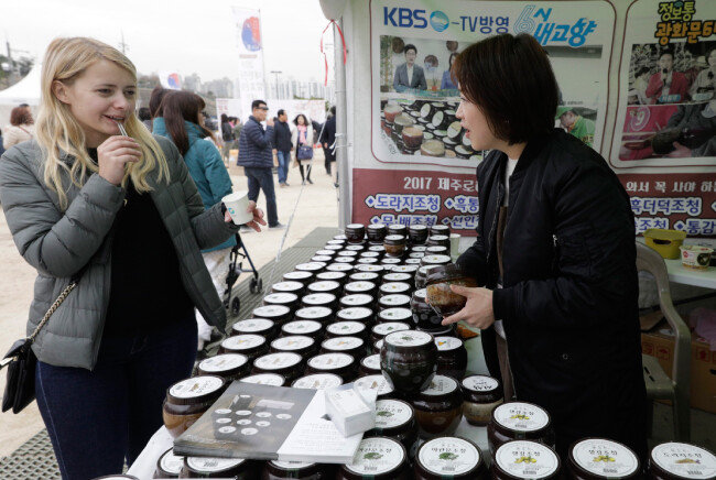 외국인 관람객이 한라산가마솥에서 만든 수제 조청을 맛보고 있다.