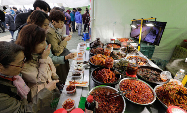 순창이조전통식품 부스에서 젓갈과 김치 등을 맛보는 사람들. 