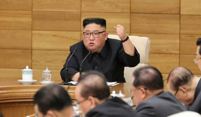 김정은 북한 국무위원장이 4월 9일 노동당 정치국 확대회의에서 왼 주먹을 불끈 쥐며 ‘자력갱생’을 강조하고 있다. [노동신문]