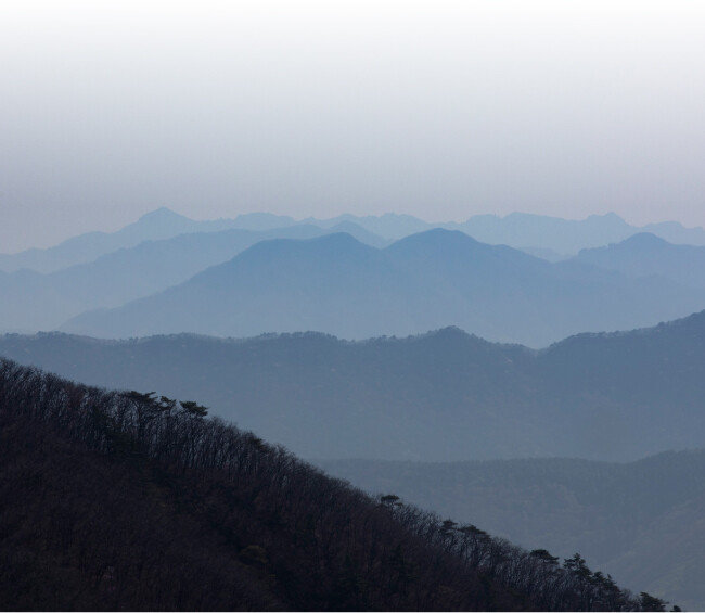 산의 정상부 뒤로 영남의 산세가 병풍처럼 펼쳐져 있다.