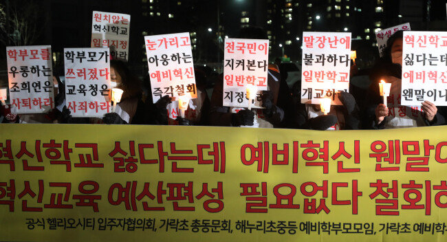지난해 12월 혁신학교 지정에 반대하는 송파구 헬리오시티 입주 예비 학부모들이 서울시교육청 앞에서 촛불집회를 열고 예비혁신학교 지정 반대와 조희연 교육감 사퇴를 촉구하고 있다. [뉴스1]