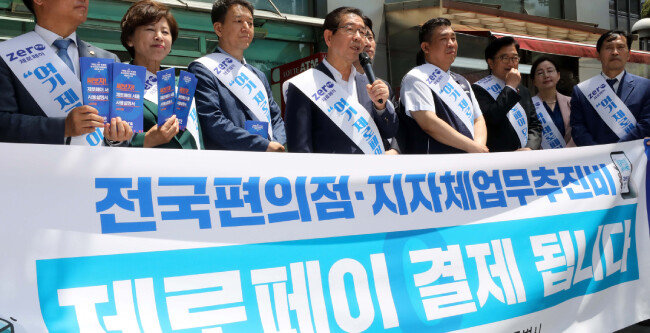 박원순 서울시장이 5월 29일 서울 여의도 금융가에서 '여기 제로페이 되죠?'라고 쓰인 어깨띠를 두르고 시민들에게 제로페이 홍보 캠페인을 하고 있다.  [뉴스1]
