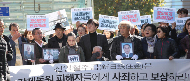 2018년 10월 30일 서울 서초구 대법원 앞에서 일제 강제징용 피해자들이 먼저 세상을 떠난 동료 피해자들의 영정을 들고 법정으로 향하고 있다. 이날 대법원 전원합의체는 이춘식(95) 씨 등 일제 강제징용 피해자들의 손을 들어줬다. [신원건 동아일보 기자]