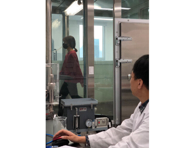 마스크 착용자가 체임버에 들어가 누설률 시험을 하는 모습. [한국의류시험연구원 제공]