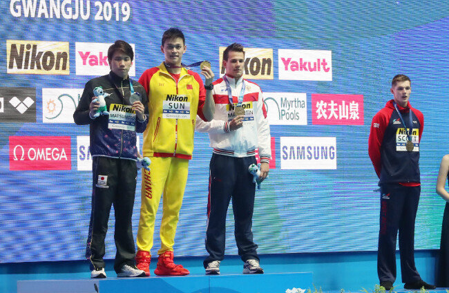 2019 광주세계수영선수권대회 남자 자유형 200m 결승 시상식, 금메달을 획득한 중국의 쑨양(왼쪽에서 두 번째)이 다른 메달리스트들과 기념촬영을 하는 가운데 함께 동메달을 획득한 영국의 던컨 스콧(오른쪽)이 멀리 서 있다. [뉴시스]