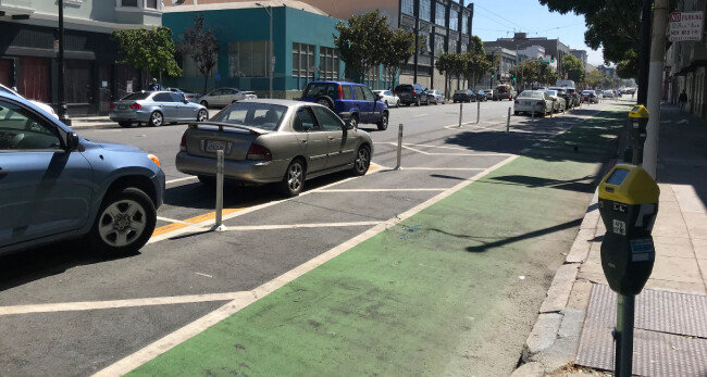 3월 자전거 운전자 사망사고 이후 샌프란시스코 교차로 주변에 설치된 자전거 보호도로. 차량 진행 방향 기준으로 맨 오른쪽이 녹색으로 칠해진 자전거 보호도로다. 자전거도로와 일정한 간격을 두고 왼쪽에 마련된 노상주차장에 자동차들이 일렬로 주차돼 있다. 이 주차장 왼쪽이 차도다.