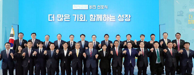문재인 대통령이 3월 21일 서울 중구 IBK 기업은행 본점에서 열린 혁신금융 비전선포식에서 금융지주 대표, 기업 대표들과 함께 ‘기업과 금융이 함께 간다’는 의미로 손을 맞잡고 기념촬영하고 있다. [청와대 페이스북]
