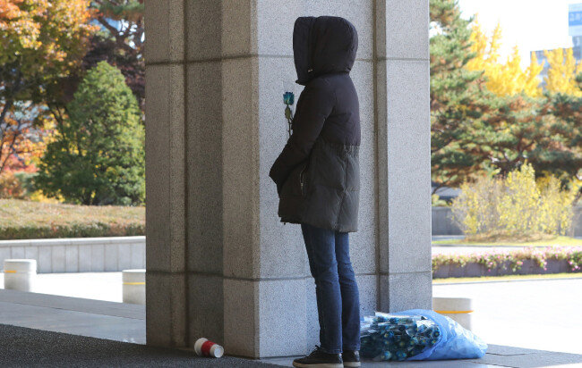 조국 전 법무부 장관이 피의자 신분으로 검찰에 출석한 11월 14일, 지지자 한 명이 파란색 장미를 들고 서울 서초동 서울중앙지검 입구에 서 있다. 파란색 장미의 꽃말은 ‘기적’ ‘희망’ ‘포기하지 않는 사랑’이다.  [뉴스1]