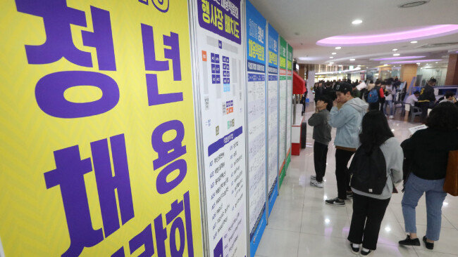 기업들의 해외 진출이 가속화될 때 최대 피해자는 취업을 앞둔 세대다. 11월 7일 부산 사상구 동서대 스튜던트플라자 3층에서 열린 ‘청년 채용박람회’를 찾은 학생과 구직자들이 채용 게시판을 살펴보고 있다. [뉴스1]