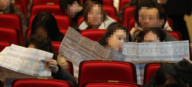 2019년 12월 10일 서울 노원구 광운대에서 열린 2020 대입 정시전형 대비 진학설명회에서 수험생 학부모들이 배치표를 살펴보고 있다. [뉴스1]