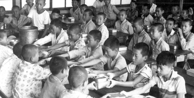 1960년대 초등학교 풍경. 학생들이 도시락을 싸오지 못한 친구에게 도시락을 건네주고 있다. [동아DB]