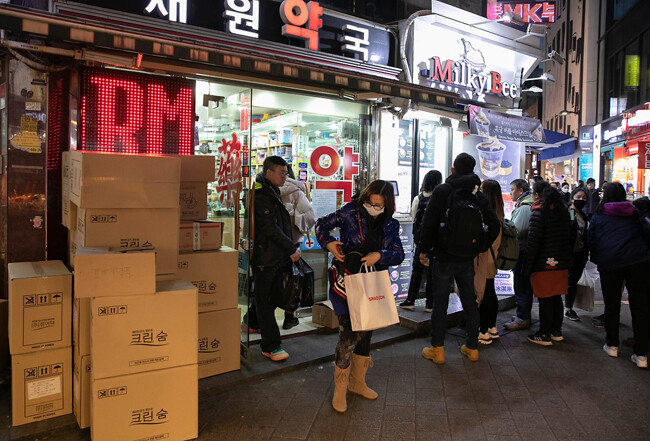 약국 앞에 마스크 박스가 놓인 채 줄을 선 관광객들