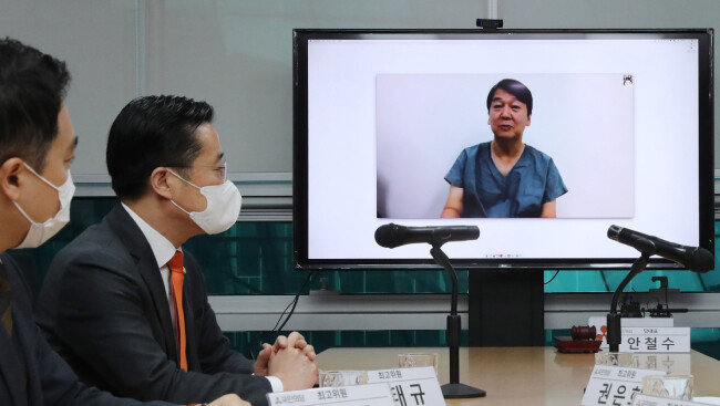 대구에서 코로나19 자원봉사를 하는 안철수 국민의당 대표가 3월 9일 서울 여의도 국회 의원회관에서 열린 최고위원회의에 화상으로 참여해 발언하고 있다. [뉴시스]