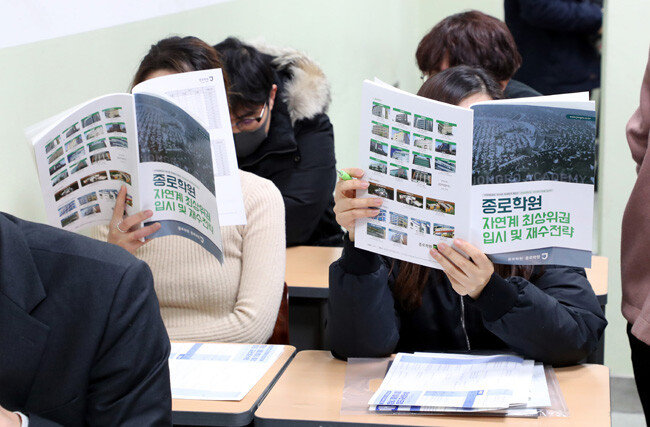 2019년 1월 서울 종로학원 강남본원에서 열린 ‘자연계 최상위권 입시 및 재수전략 설명회’ 참석자들이 안내 자료를 읽고 있다. [최혁중 동아일보 기자]