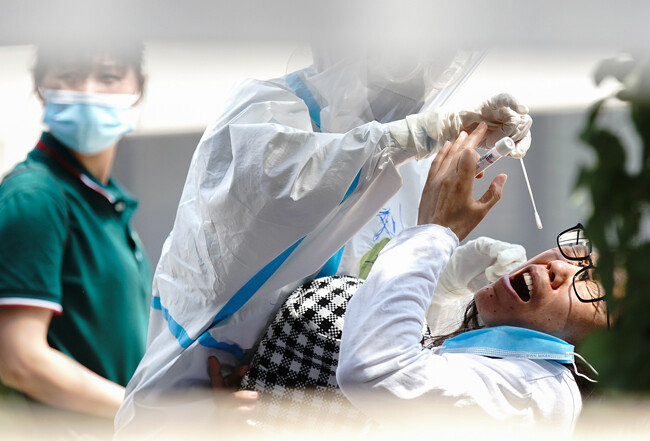 6월 16일 중국 베이징시의 한 검사시설에서 방역복을 착용한 간호사가 코로나19 검사를 하고 있다.