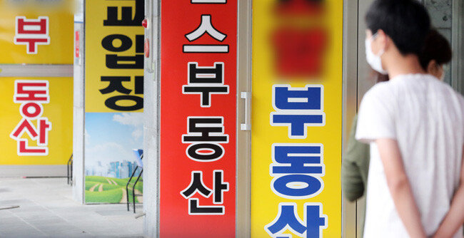 6월 17일 경기 수원시 한 부동산중개업소 앞을 지나가는 시민들의 모습. [뉴스1]