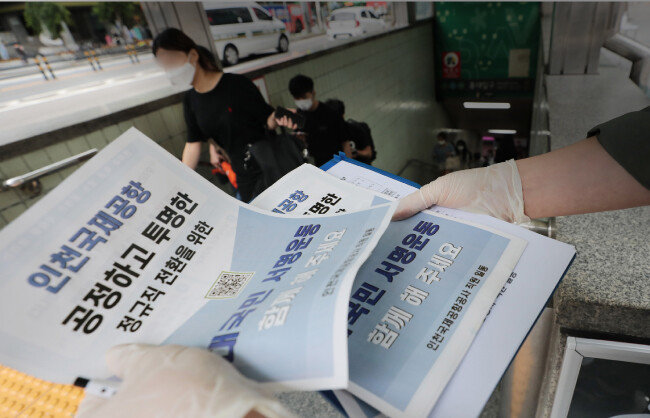 6월 30일 서울 마포구 서울지하철 2호선 홍대입구역 앞에서 인천국제공항공사 직원들이  보안검색요원 정규직 전환 절차를 문제 삼는 내용의 전단지를 배포하고 있다. [뉴스1]