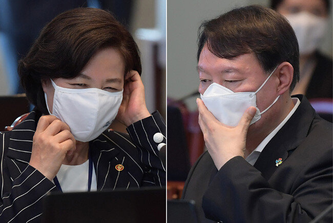 6월 22일 청와대에서 열린 제6차 공정사회 반부패정책협의회에 참석한 추미애 법무부 장관(왼쪽)과 윤석열 검찰총장이 각각 마스크를 고쳐 쓰고 있다. [청와대 사진기자단]