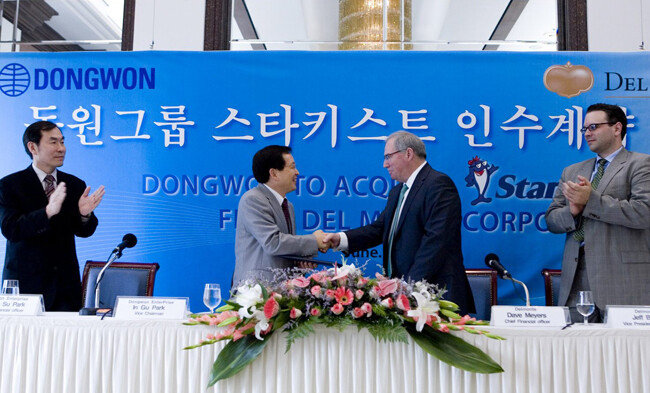2008년 6월 30일 서울 중구 프레스센터에서 열린 동원그룹의 스타키스트 인수 체결식. 박인구 동원그룹 부회장(왼쪽)이 데이브 메이어스 델몬트 최고재무책임자와 악수하고 있다. [사진제공 동원그룹]