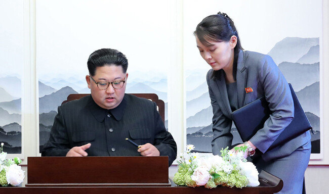 김정은 북한 국무위원장이 2018년 4월 27일 판문점에서 열린 ‘한반도의 평화와 번영, 통일을 위한 판문점 선언’ 서명식에서 김여정 노동당 제1부부장의 도움을 받아 선언문에 서명을 하고 있다. [한국사진공동취재단]