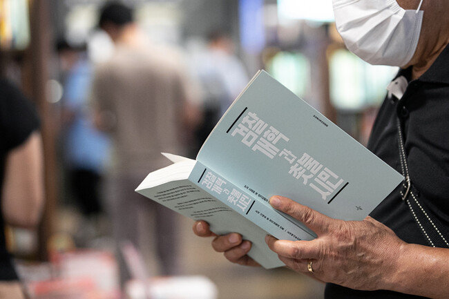 8월 12일 서울 한 대형서점에서 한 시민이 ‘검찰개혁과 촛불시민’(조국 백서)을 살펴보고 있다. [뉴스1]