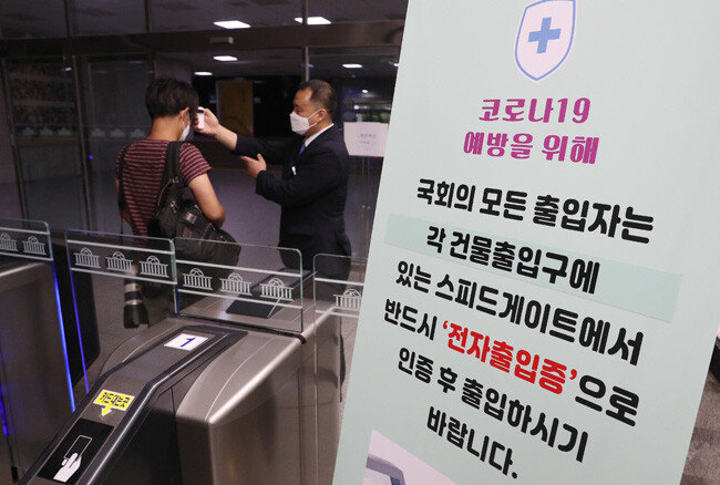 6일 오전 서울 여의도 국회의사당 입구에서 출입자가 발열검사를 받고 있다. [뉴스1]