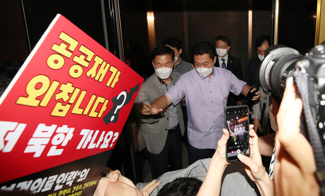 박능후 보건복지부 장관이 9월 4일 서울 중구 한국건강증진개발원에서 정부와 대한의사협회의 협약식에 참석하려다 전공의와 전임의들의 항의를 받으며 장소를 빠져나가고 있다. 그 사이로 전공의들이 자신들의 처지를 ‘공공재’에 빗댄 피켓이 보인다. [송은석 동아일보 기자]