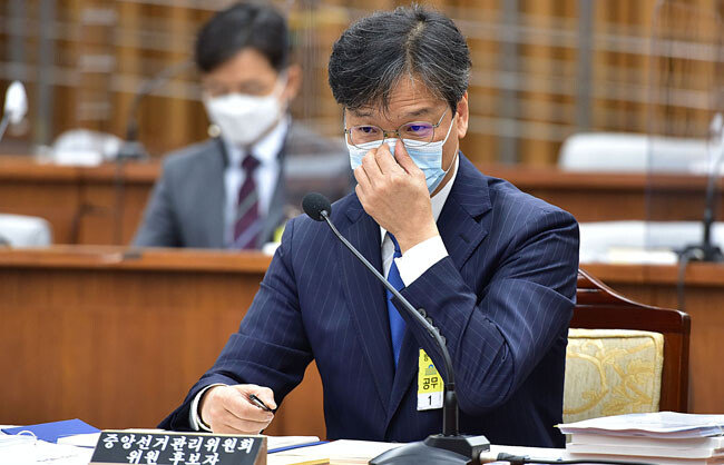 조성대 중앙선거관리위원 후보자가 22일 서울 여의도 국회에서 열린 인사청문회에서 마스크를 만지고 있다. [김재명 동아일보 기자]