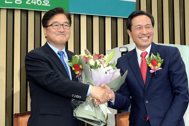 9월 23일 ‘민주유공자 예우에 관한 법률안’을 대표 발의한 우원식 더불어민주당 의원(왼쪽)과 공동발의자로 이름을 올린 같은 당 우상호 의원. 사진은 두 사람이 2017년 5월 16일 민주당 원내대표 경선 뒤 악수하는 모습. [최혁중 동아일보 기자]