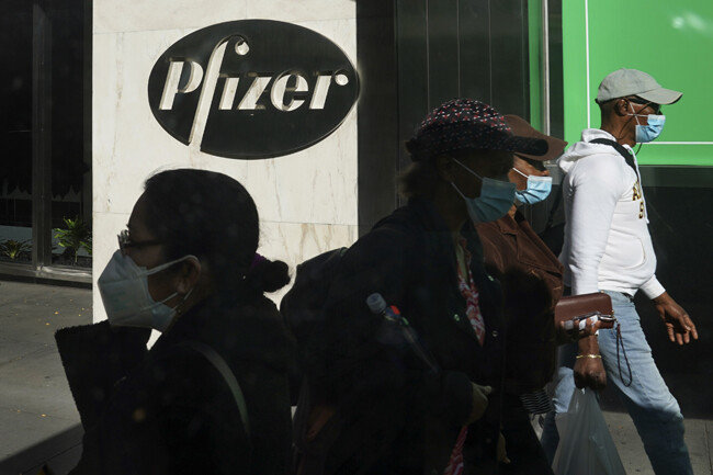 미국 제약사 화이자가 독일 기업 바이오엔테크와 공동으로 개발 중인 코로나19 백신의 예방효과가 90% 이상인 것으로 확인됐다고 발표한 11월 9일(현지 시간) 마스크를 착용한 시민들이 미국 뉴욕 화이자 본사 앞을 지나고 있다. [뉴욕=AP뉴시스]