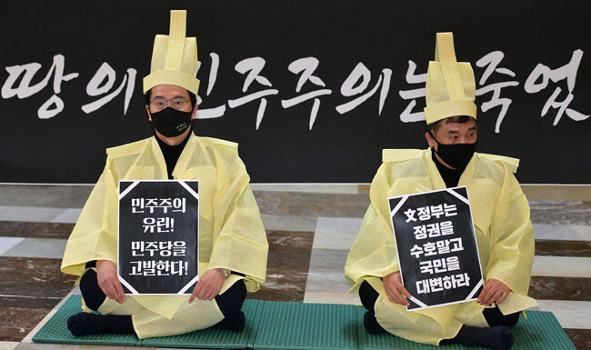 국민의힘 강민국(왼쪽)·최승재 의원이 12월 10일 국회 로텐더홀에서 고위공직자비리수사처법 개정안 본회의 통과와 관련, 상복을 입고 규탄하고 있다. [뉴시스]
