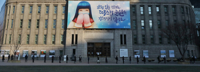 21일 서울 중구 서울시청 앞에 마련된 코로나19 임시선별검사소 앞에 진단검사를 기다리는 시민들이 길게 늘어서 있다. [뉴스1]