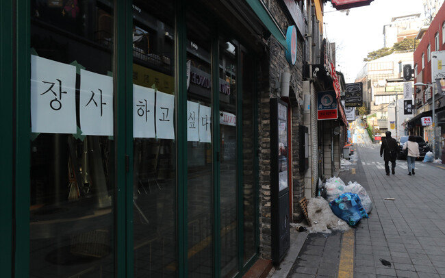 1월 14일 서울 용산구 이태원 거리에서 코로나19 타격으로 사실상 폐업절차를 밟고 있는 한 가게에 ‘장사하고 싶다’는 글귀가 붙어 있다. [홍진환 동아일보 기자]