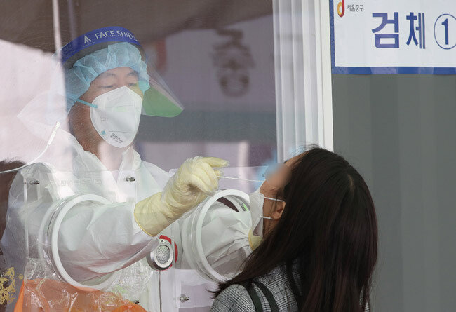 4월 15일 서울 중구 서울역 광장에 마련된 중구 임시선별진료소에서 한 시민이 코로나19 검사를 위해 검체를 채취고 있다. [뉴스1] 
