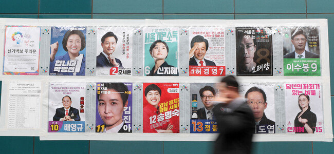 3월 29일 서울 중구 무교동에 붙은 서울시장 보궐선거 벽보 앞을 한 시민이 걸어가고 있다. [송은석 동아일보 기자]