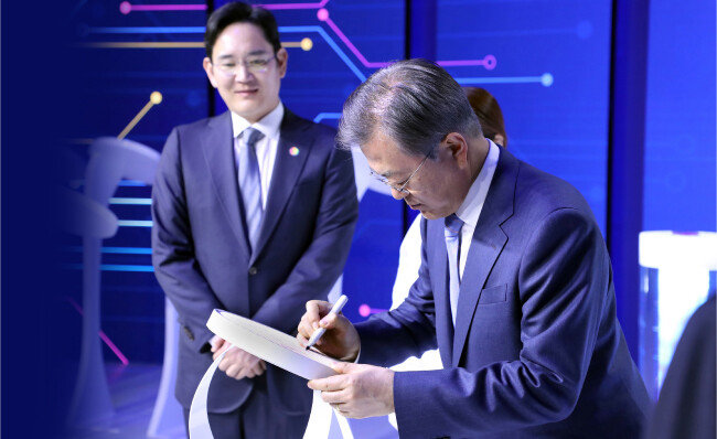 문재인 대통령(오른쪽)이 2019년 4월 30일 경기 화성 삼성전자 화성사업장에서 열린 ‘시스템반도체 비전 선포식’에서 이재용 삼성전자 부회장이 지켜보는 가운데 EUV공정 7나노로 출하된 웨이퍼 칩에 서명하고 있다. [청와대사진기자단]