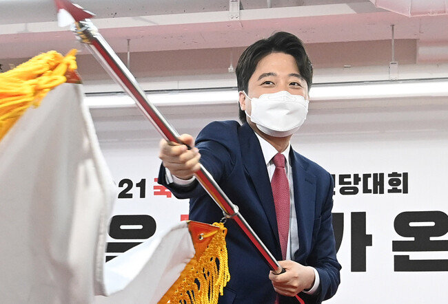 이준석 신임 국민의힘 당대표가 6월 11일 서울 여의도 국민의힘 당사에서 열린 전당대회에서 당기를 흔들고 있다. [뉴시스]