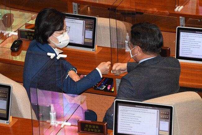 2020년 12월 10일 추미애 당시 법무부 장관(왼쪽)과 윤호중 당시 국회 법제사법위원장(더불어민주당)이 서울 여의도 국회 본회의장에서 고위공직자범죄수사처(공수처)법 개정안이 통과된 뒤 주먹 인사를 나누고 있다. [김동주 동아일보 기자]