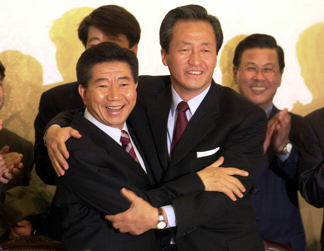 2002년 11월 16일 당시 새천년민주당 노무현 후보(왼쪽)와 국민통합21 정몽준 후보가  서울 여의도 국회 귀빈식당에서 후보단일화 방식과 절차에 전격 합의한 뒤 서로 얼싸안고 있다. [동아DB]